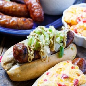 Grilled Brats topped with Pimento cheese and Green Tomato Chow Chow.