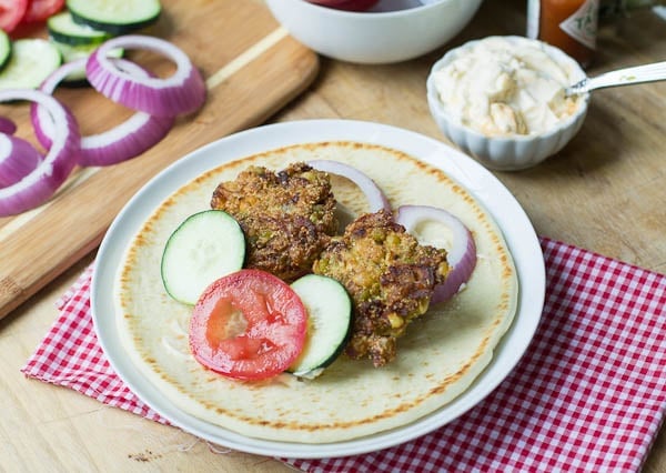 Falafel on pita bread with red onion, tomato, and cucumber.