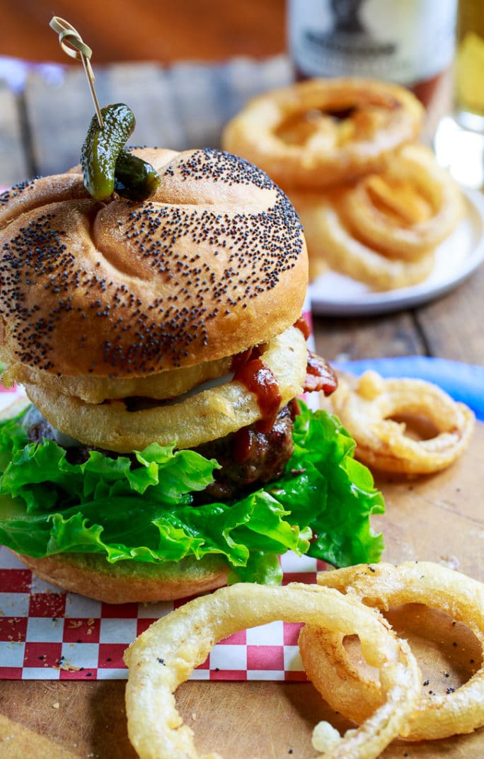 Cowboy Burgers topped with bacon, onion rings, and bbq sauce.