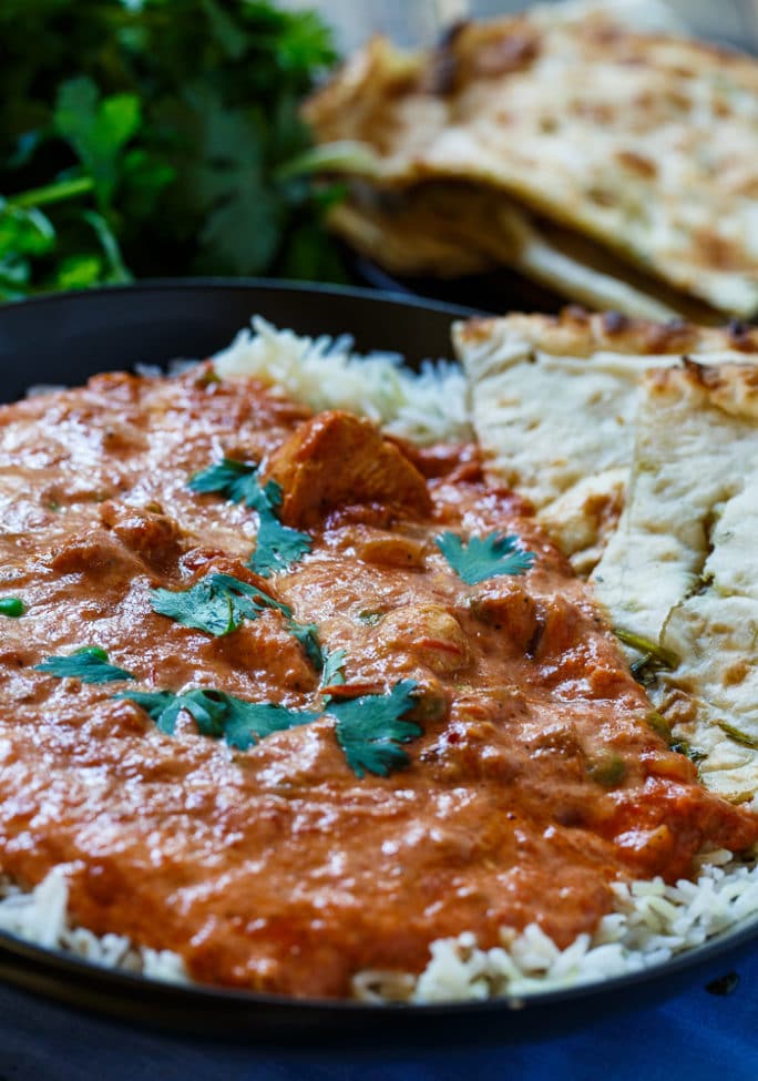 Slow Cooker Chicken Tikka Masala over rice with fresh cilantro and naan.