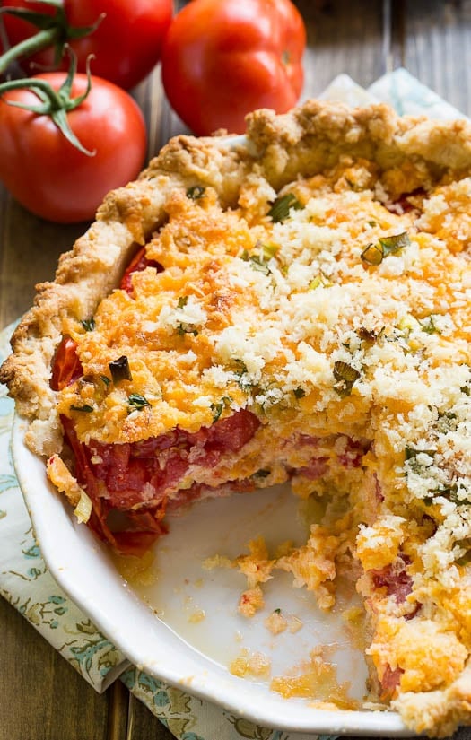 Savory Tomato Pie- a southern favorite. Juicy summer tomatoes mixed with mayonnaise and cheddar cheese. Serve warm.