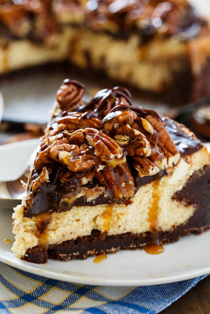 Turtle Brownie Cheesecake with a brownie crust, and pecans, caramel sauce and chocolate sauce on top.