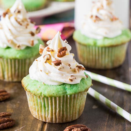Watergate Cupcakes flavored with pistachio pudding and pineapple. Topped with a marshmallow fluff frosting.