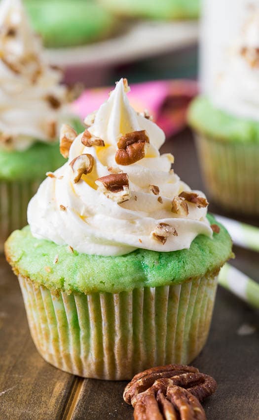 Watergate Cupcakes flavored with pistachio pudding and pineapple. Topped with marshmallow fluff frosting.